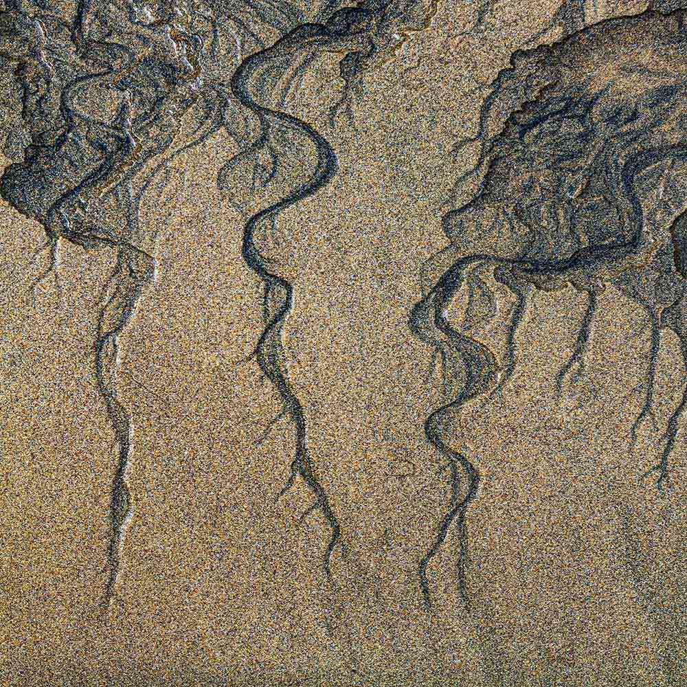 strands | Blue black manganese revealed by the receding tide on a Breton beach