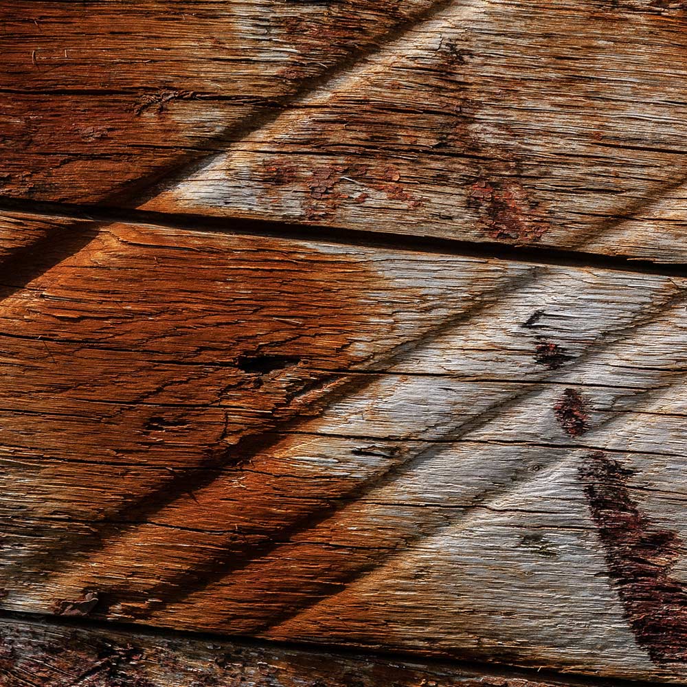 Camaret-sur_mer | bare wooden side of a rotting hulk of a fishing boat with incised, abraided grooves made by ropes with no paint